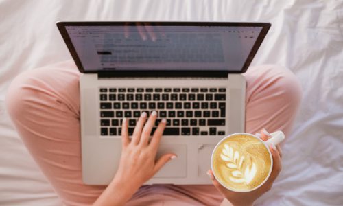 woman typing on laptop with coffee