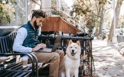 man on laptop with dog